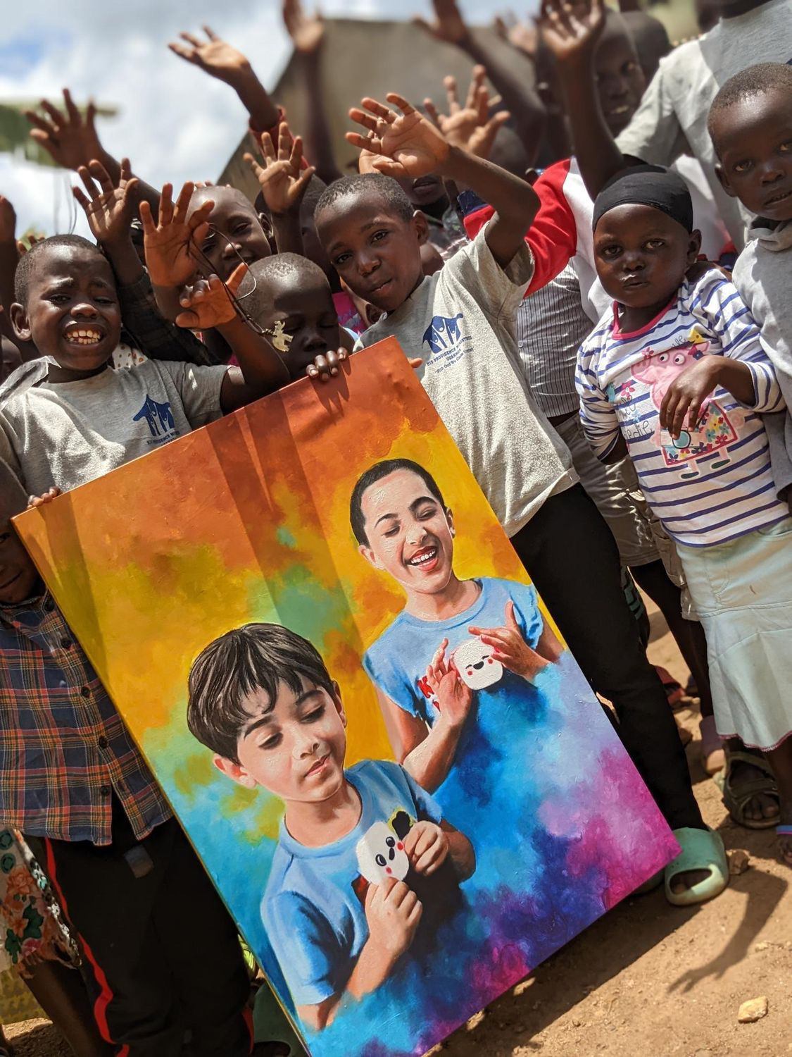 Children at the orphanage proudly holding up the painting